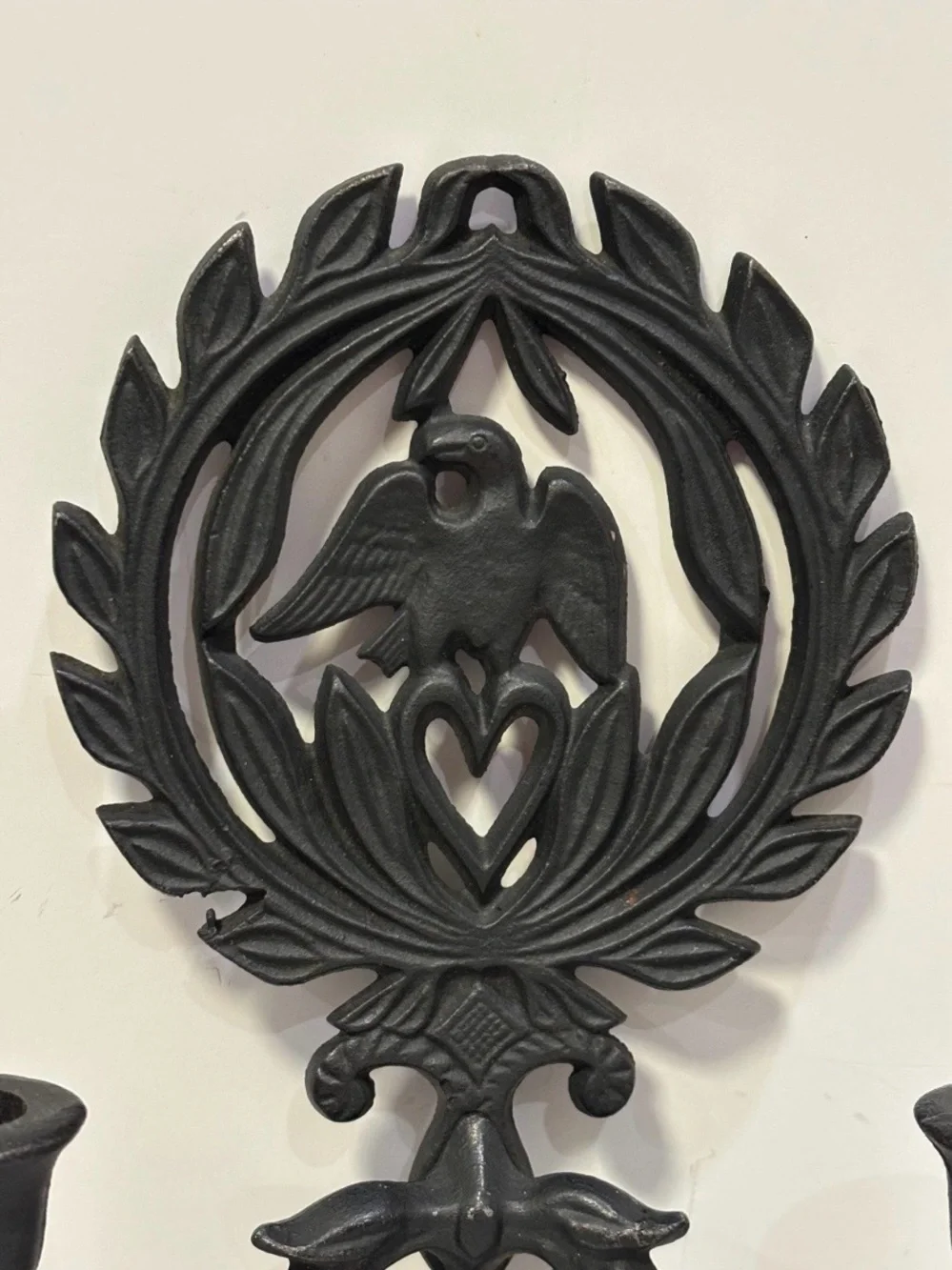 A pair of vintage cast iron wall sconces with eagle and laurel wreath motif